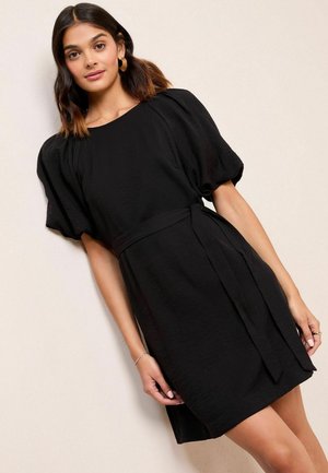 Black short dress with puff sleeves, waist tie, and a textured fabric. Simple design features a round neckline and a straight hem.