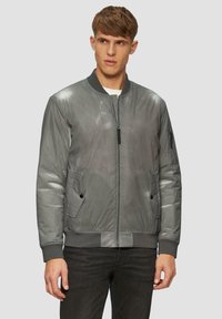 Graue Bomberjacke mit glatter Textur, gerippem Kragen und Bündchen, vorderen Taschen und einem Reißverschluss auf der Vorderseite zum Schließen.