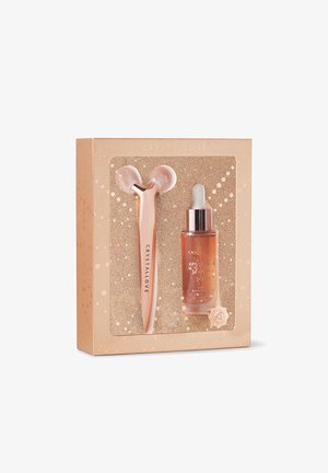 Roze gouden gezichtroller en serum in een decoratieve doos met glinsterende accenten, met afgeronde vormen en een glazen textuur.