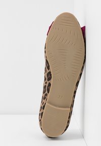 Chausson plat à imprimé léopard avec une tige en tissu doux et une semelle en caoutchouc. Présente un accent bordeaux au niveau du talon. Taille indiquée comme 37.