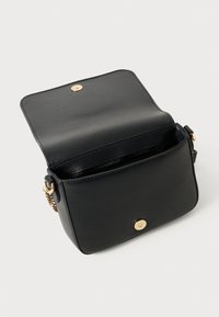 Borsa a tracolla nera in pelle testurizzata, con chiusura a patta e bottone dorato, e dettaglio in catena dorata sulla tracolla.