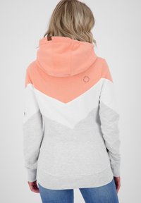 Felpa con cappuccio caratterizzata da una sezione superiore arancione, una parte centrale bianca e un fondo grigio. Realizzata in tessuto morbido con un design a zigzag sul retro.