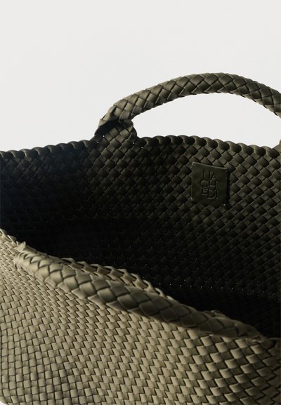 Τσάντα ώμου από πλεγμένο σκούρο ελιά με πλεγμένες λαβές και ένα μικρό τετράγωνο λογότυπο στη μέσα πλευρά κοντά στο επάνω άκρο.