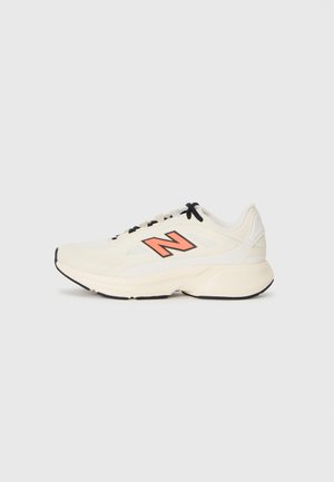 Κρέμα αθλητικό sneaker με μαύρες κορδόνες, παχύ πέλμα και πορτοκαλί λογότυπο "Ν" στο πλάι, απεικονιζόμενο από την αριστερή προφίλ σε λευκό φόντο.