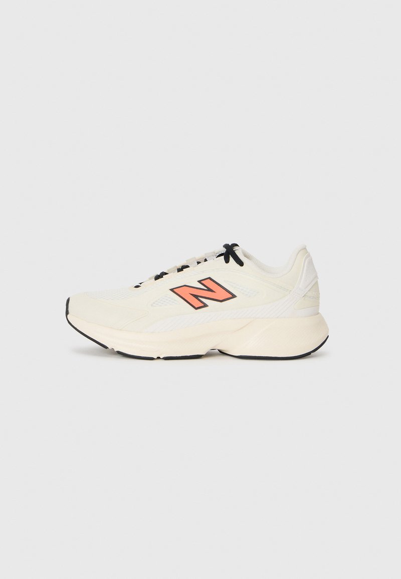 Sneaker sportiv de culoare crem cu sireturi negre, talpă groasă și logo-ul portocaliu „N” pe lateral, prezentat din profil stâng pe fundal alb.