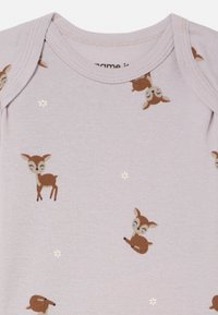 Ροζ βαμβακερό φορμάκι με σχέδιο ελαφιού και μικρές λευκές ανθισμένες λεπτομέρειες. Στρογγυλεμένος λαιμός με απαλή, λεία υφή.