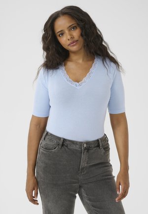 Haut bleu clair côtelé avec un décolleté en V profond et une bordure en dentelle, associé à un pantalon en denim gris, présentant une coupe décontractée et des détails texturés subtils.