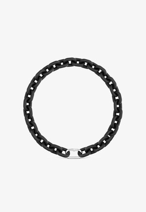 Catena rotonda nera con grandi maglie e un anello di chiusura color argento al centro in basso su sfondo bianco.