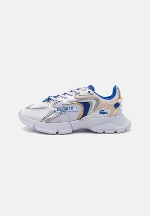 Baskets Lacoste blanches et bleues avec panneaux en mesh, semelle épaisse et détail du logo sur le côté et le talon en vue de profil.