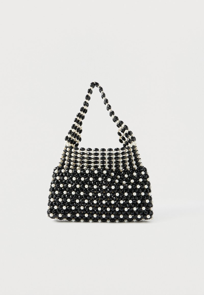 Mustvalge helmestega käekott lühikese käepidemega, mis on tehtud vahelduvatest pärlilaadsetest ja mustadest tahulistest helmestest ruudulisemas mustris.