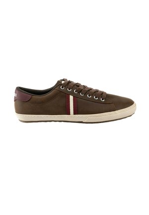 Zapatilla deportiva marrón de caña baja con cordones marrón oscuro, rayas laterales rojas y blancas, y suela beige.