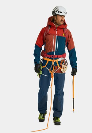 Outdoor climbing gear features a red and blue jacket, navy pants, gloves, and a helmet. Includes climbing hardware and an ice axe.