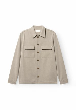 Beige langärmliges Hemd mit Knöpfen, zwei Brusttaschen mit Klappen und spitzem Kragen vor weißem Hintergrund.