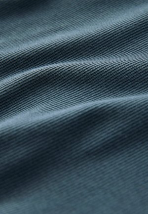 Tissu texturé en bleu foncé avec des nervures diagonales. Doux, avec un éclat subtil, affichant des plis doux et une surface lisse.