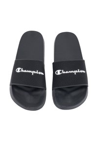 Black slide sandals with textured rubber soles, featuring a perforated band. "Champion" logo in white displayed prominently on the band.