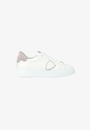 Sneaker bassa bianca con tallone in suede decorato con perline simili a perle rosa e bianche, design con lacci e una toppa a forma di scudo sul lato.