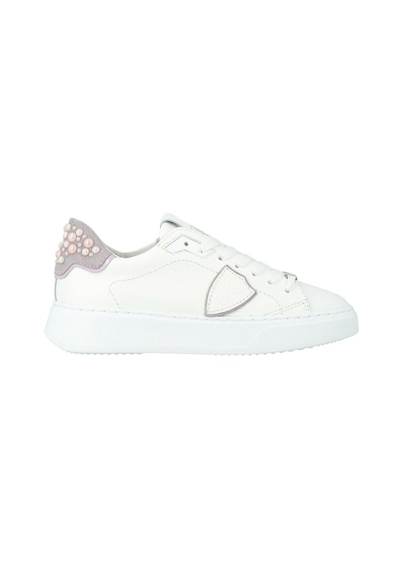 Sneaker bassa bianca con tallone in suede decorato con perline simili a perle rosa e bianche, design con lacci e una toppa a forma di scudo sul lato.