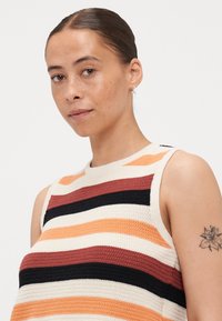 Top in maglia senza maniche con strisce orizzontali multicolori in arancione, nero e crema. Presenta un colletto a girocollo.