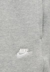 Γκρι φούτερ από απαλό, υφασμένο ύφασμα με υφή. Διαθέτει λευκό κεντητό λογότυπο Nike στο κάτω αριστερό μέρος. Απλός, καθαρός σχεδιασμός.