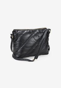 Bolso de hombro de cuero negro con costura diagonal, cierre de cremallera y correa ajustable. Textura suave con detalles en hardware dorado.