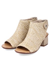 Sandales à talons tressées beige avec un orteil ouvert, une tige texturée et un talon épais. Présente une bandoulière arrière avec un bouton décoratif.