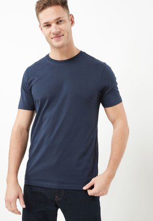 Camiseta de algodón de color azul marino con cuello redondo y mangas cortas, que presenta una textura suave y una forma ligeramente ajustada.