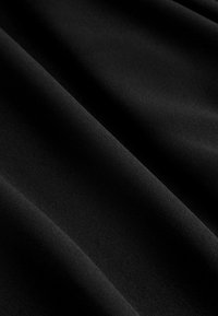 Black fabric with a smooth texture, featuring soft draping and subtle sheen. The material is lightweight and opaque.
