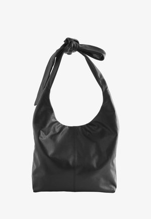 Sac à bandoulière en cuir noir souple avec une large sangle nouée et une ouverture supérieure incurvée.