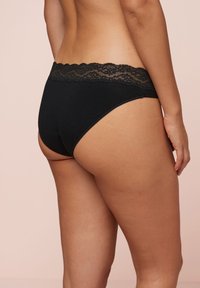 Zwarte katoenen onderbroek met een geschulpte kant tailleband, klassieke snit, met een soepele textuur en zonder zichtbare naden.