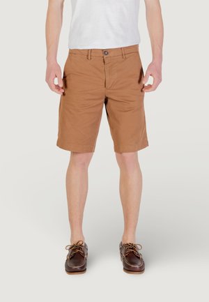 Shorts en coton marron avec une coupe droite, dotés d'une fermeture à bouton, de passants de ceinture et de poches latérales, associés à des chaussures bateau marron foncé.
