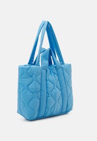 Gequilted blauwe draagtas met dubbele handvatten. Beschikt over een gestructureerd oppervlak met een golvend patroon en contrasterende banden. Compact en lichtgewicht ontwerp.