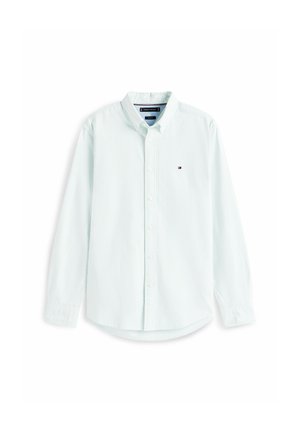 Hvid skjorte med lange ærmer med diskrete lodrette striber og en lille broderet logo på venstre bryst.