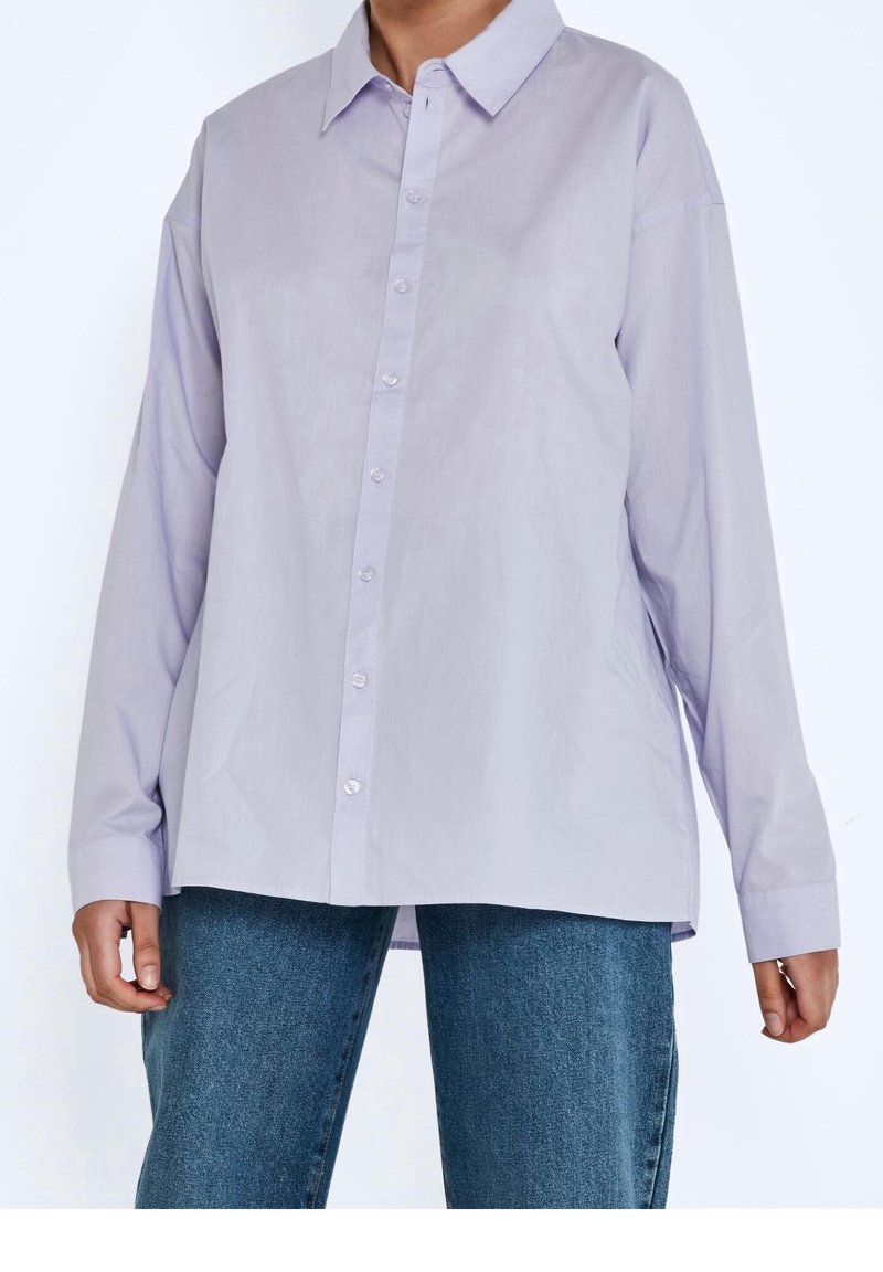 Camicia button-up di un leggero lilla con maniche lunghe, colletto classico e taglio dritto. Presenta una texture liscia e piccoli bottoni trasparenti.