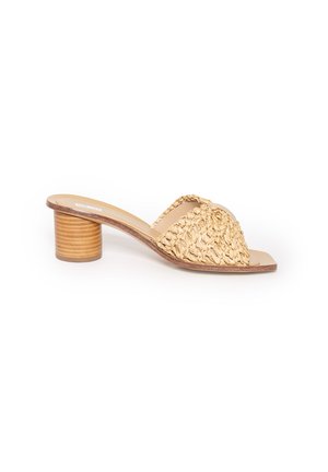 Beżowe mule z odkrytymi palcami, plecioną cholewką i nałożonym na siebie blokowym obcasem na białym tle.