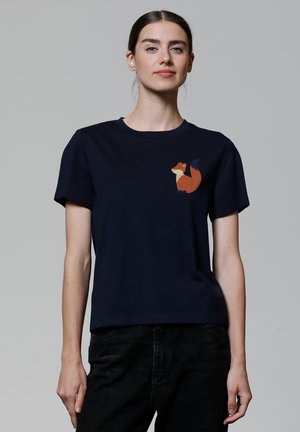 T-shirt en coton bleu marine à manches courtes avec un graphique de renard marron et orange sur la poitrine gauche. Encolure ronde simple, coupe décontractée.