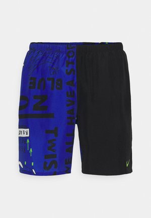Shorts bleus et noirs présentant un mélange de texte audacieux et de graphiques. Fabriqués en matériau léger avec une taille élastique et le logo Nike.