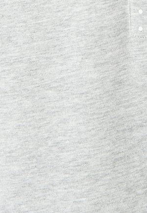 Maglietta a maniche corte grigio chiaro realizzata in tessuto morbido, caratterizzata da una superficie texture con un leggero motivo melangiato e collo a tre bottoni.