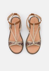 Bruine leren sandalen met gouden banden en een slangenhuidpatroon op de teen. Open ontwerp met een gesp- sluiting en platte zool. Maat 37.