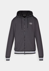 Tamsiai pilkas zip-up gobtuvėlis su tekstūruotu audiniu, juodais akcentais, baltais dryžuotais rankogaliais ir apykakle, bei siuvinėtu logotipu ant krūtinės.