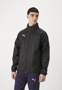 Black lightweight jacket with high collar, full-length zipper, and elastic cuffs. Features a white Puma logo on the left chest.