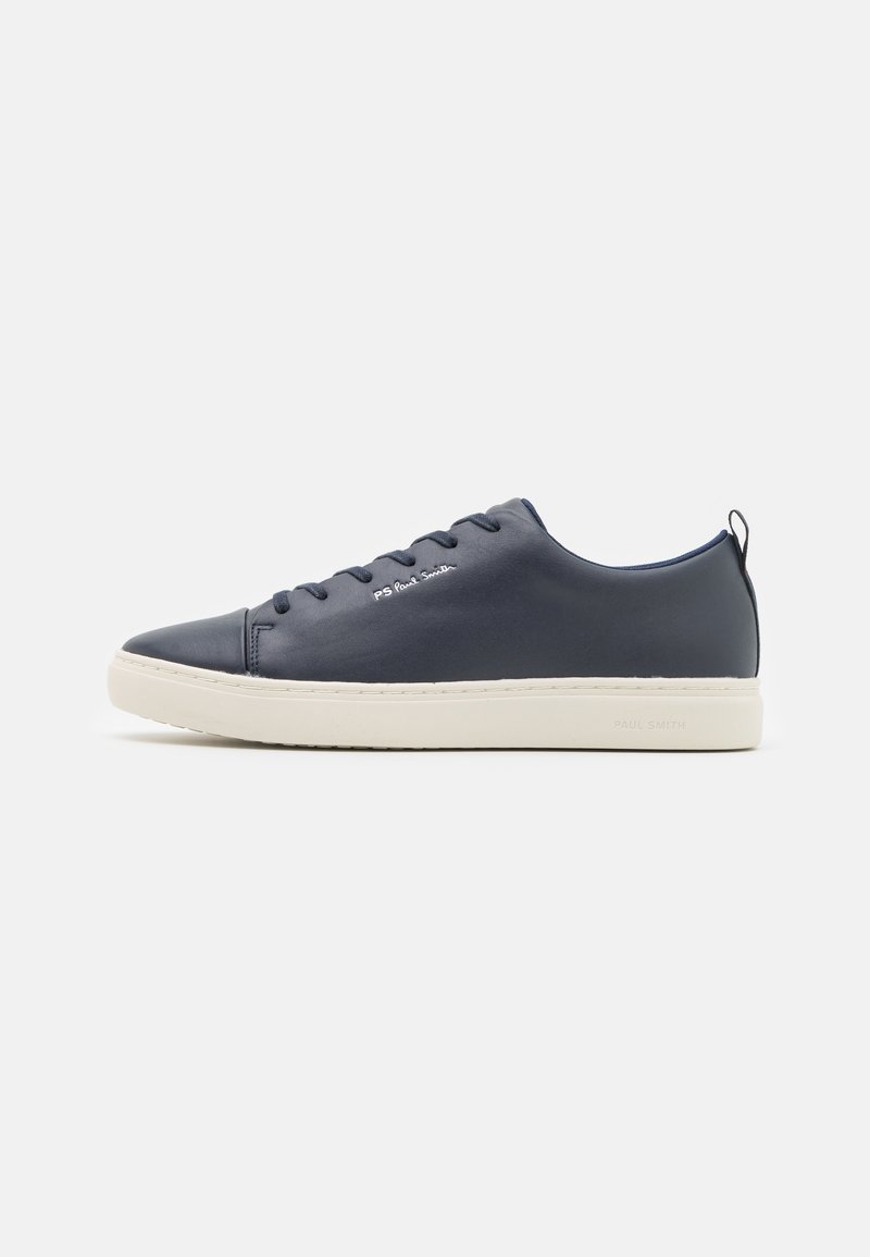Vue latérale d'une basket en cuir bleu marine à coupe basse avec semelle blanche et lacets, présentant un petit logo blanc sur le côté.