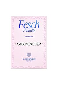 Pulsera de plata de ley con cuentas blancas que forman la palabra "BUSSI" y un ícono de corazón, presentada en una tarjeta rosa con patrones de corazones.