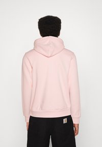 Vista trasera de una sudadera rosa clara con capucha con cordón, puños y dobladillo acanalados; material de algodón, textura suave, diseño minimalista.