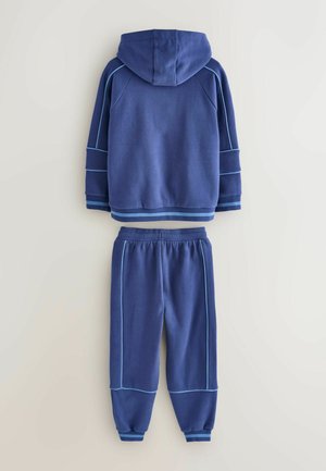 Mørkeblå hoodie med hætte og kontrasterende lyseblå sømme, parret med matchende joggerbukser med elastiske manchetter og snoretræk i livet.