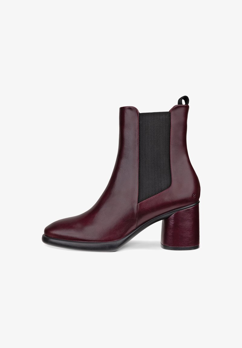 Bottine en cuir bordeaux avec un grand panneau élastique noir et un talon géométrique. Texture lisse avec un profil à bout pointu.