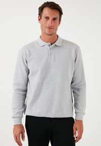 Polo shirt gris de manga larga, mezcla de algodón, con cuello clásico, tapeta de tres botones, puños acanalados y dobladillo recto.