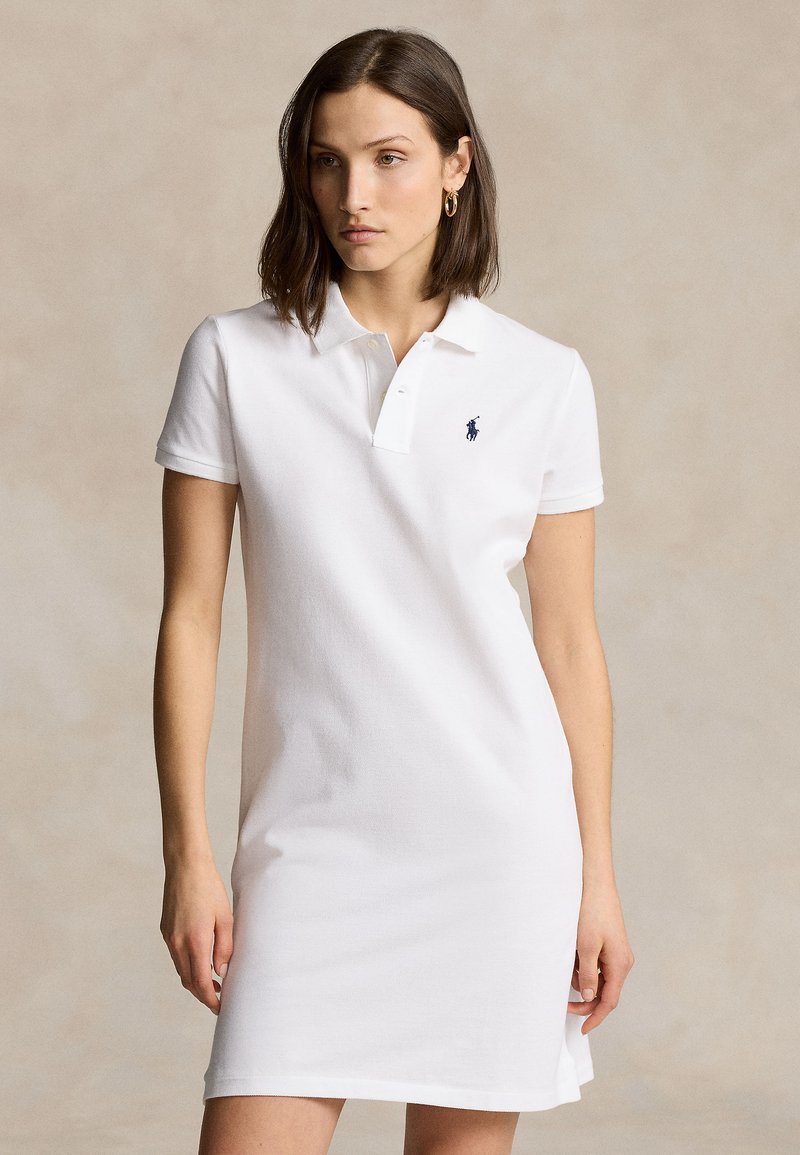 Λευκό φόρεμα πόλο από υφασμένο βαμβάκι με γιακά, κοντά μανίκια και μικρό ναυτικό λογότυπο στο αριστερό στήθος.