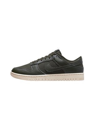 Nike sneakers i mørkegrødt læder, lavtop design med en beige gummisål, med rund tå og standard snørebåndslukning.