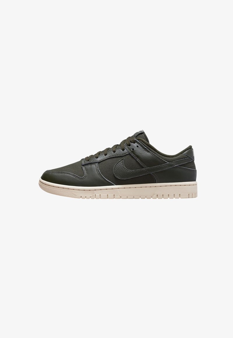 Nike-Sneaker aus dunkelgrünem Leder, mit niedrigem Schnitt und einer beige Gummi-Sohle, ausgestattet mit einer runden Zehenform und herkömmlichem Schnürverschluss.