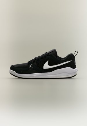 Μαύρο και λευκό αθλητικό παπούτσι Nike με επάνω μέρος από δίχτυ και σουέντ, λευκό λογότυπο Swoosh και παχιά λευκή σόλα με ουδέτερο φόντο.